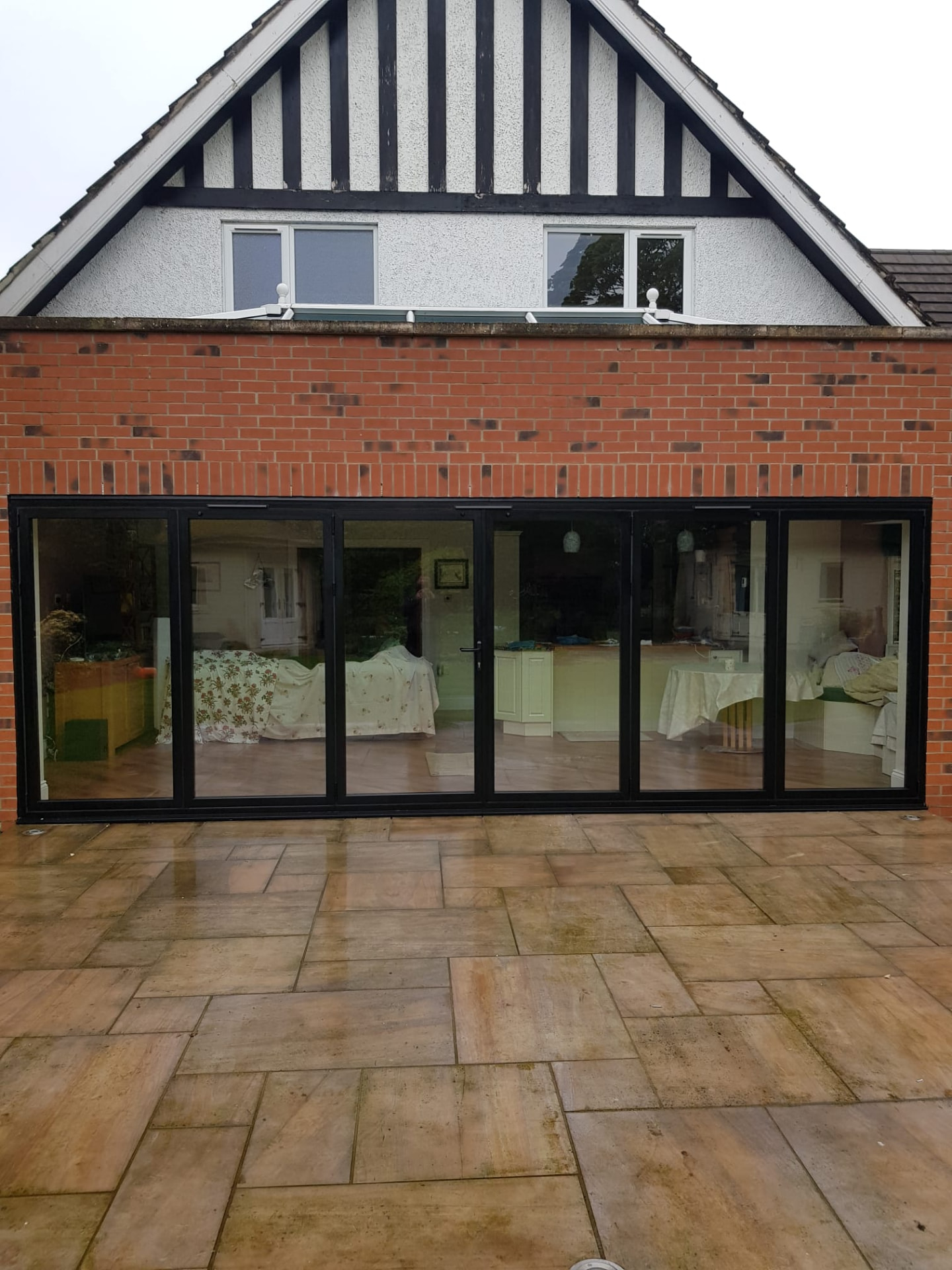 Anthracite bifold doors on a gable extension, supplied and installed by WGS Glazing